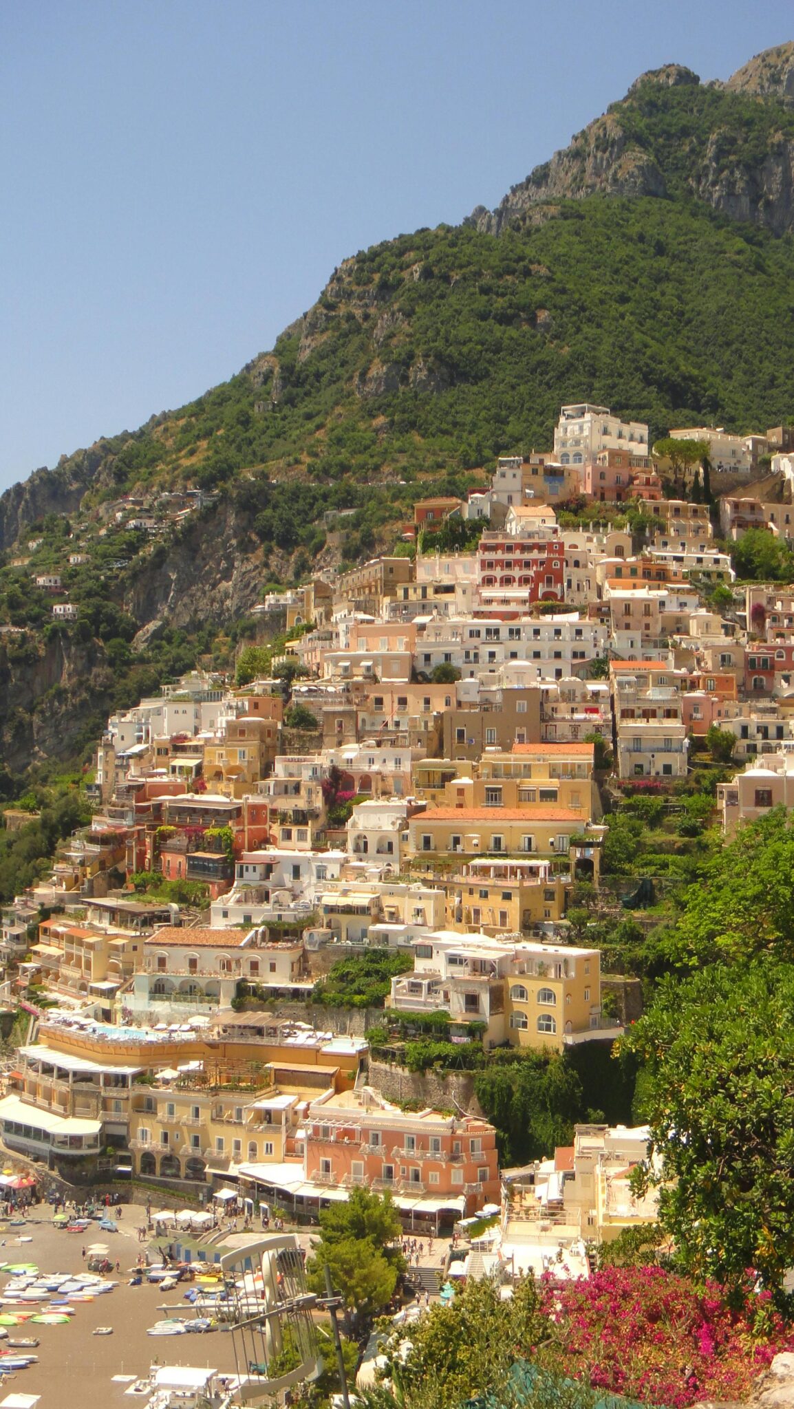 Stunning hillside view of the colorful houses of Positano on the Amalfi Coast under a clear blue sky.
